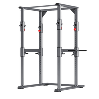 Thumbnail for A heavy-duty steel frame power cage designed for strength training, featuring safety bars and J-hooks.
